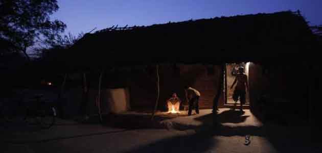 Boys sit next to a fire outside their house on a cold winter evening in a village in Uttar Pradesh.