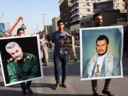 Iraqi demonstrators hold up pictures of prominent Shiite leaders from Yemen and Iran in March 2015.