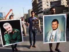 Iraqi demonstrators hold up pictures of prominent Shiite leaders from Yemen and Iran in March 2015.